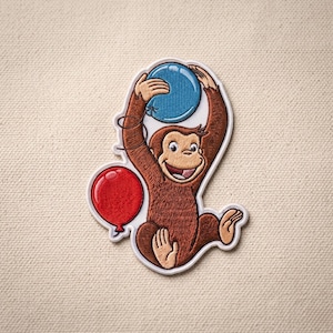 May include: An embroidered patch featuring a brown monkey with a smiling expression, holding a blue balloon above its head with both hands, while a red balloon floats to the left side of its body, all outlined in a white border on a fabric surface.
