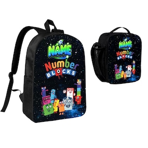 May include: A black backpack and a matching lunch bag featuring a space-themed background with colorful Numberblocks characters. The front of both items displays the text "NAME" in green and "Number BLOCKS" in blue, red, and white lettering.