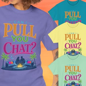May include: A collection of short-sleeved t-shirts in purple, teal, yellow, and light green. Each shirt features the text "CAN I PULL YOU FOR A CHAT?" above a graphic of two people sitting on a curved sofa by a fire pit with palm trees.
