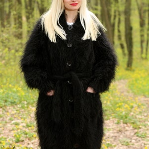 May include: A long black fuzzy cardigan with a belt and button closure. The cardigan is made of a soft, fluffy material and has a relaxed fit.