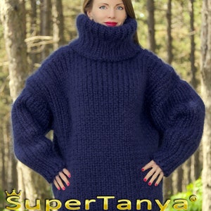 May include: A deep blue, oversized turtleneck sweater made of soft, fuzzy yarn. The sweater has a relaxed fit and long sleeves. The sweater is made by SuperTanya, a company that specializes in hand-crafted knitwear.