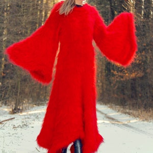 May include: A full-length, vibrant red, fuzzy coat with wide bell sleeves. The coat is worn over black boots in a snowy, wooded environment. The coat's texture appears soft and plush.