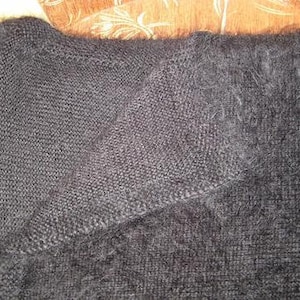 May include: A black fuzzy knit sweater with a soft, fluffy texture.