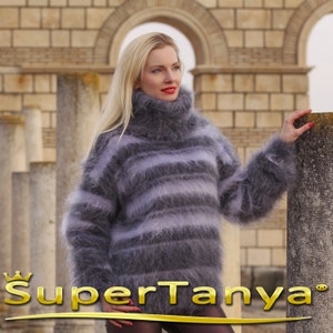 May include: A gray and white striped turtleneck sweater with long sleeves. The sweater is made of a soft, fuzzy material. The text "SuperTanya" is displayed in gold at the bottom of the image.