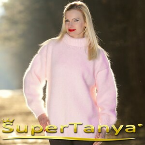 May include: A soft, pale pink fuzzy sweater with a high neck and long sleeves.