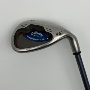 May include: A Callaway Golf Steelhead X-16 pitching wedge with a silver metal clubhead featuring a blue insert, the text Callaway Golf Steelhead X-16, and a 46 degree loft marking. The club has a dark blue shaft and a black ferrule at the hosel.