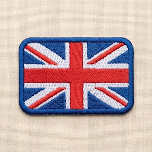 Puede incluir: Un parche rectangular bordado con el diseño de la bandera Union Jack. El parche tiene un borde azul oscuro y muestra el icónico patrón de cruces y franjas diagonales en rojo, blanco y azul característico de la bandera nacional británica.