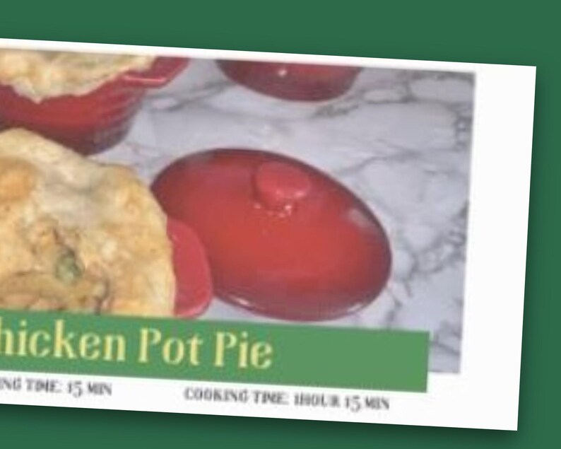 K&ouml;nnte beinhalten: Ein roter Keramiktopf mit Deckel, der ein H&uuml;hner-Pot-Pie mit goldbrauner Kruste enth&auml;lt. Das Bild zeigt ein gr&uuml;nes Banner mit dem Text Chicken Pot Pie, Prep Time: 15 min und Cooking Time: 1 hour 15 min auf einer marmorierten Oberfl&auml;che.