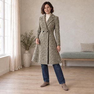 May include: A long, double-breasted coat in a muted taupe and grey floral print, featuring a structured collar, two dark buttons, and a flared silhouette, worn over a white turtleneck sweater and dark blue denim jeans with tan boots.