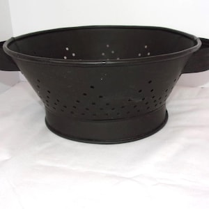 May include: A white ceramic mug with a black handle and the text "But First, Coffee" in a black, bold font. The mug is sitting on a wooden surface. The mug is approximately 4 inches tall.