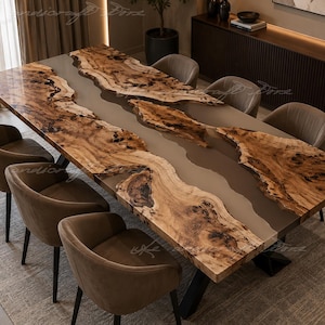 May include: A rectangular dining table featuring two natural live-edge wood slabs with a smooth, opaque beige resin river running through the center. The table is supported by black metal legs and is surrounded by six upholstered brown chairs.