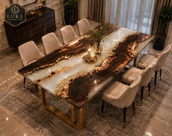May include: A rectangular dining table featuring a live edge wood slab with a central translucent white resin river design. The table is supported by gold-coloured metal legs and is surrounded by eight upholstered chairs in a light beige fabric.