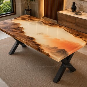 May include: A rectangular dining table featuring a live edge wood border with a central translucent resin inlay. The resin displays a gradient of cream to soft orange hues. The table is supported by a black metal base with crossed legs.