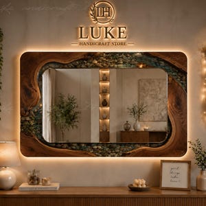 May include: A rectangular wall mirror featuring a natural live-edge wood frame with an embedded border of smooth, multi-colored river stones. The mirror is backlit with warm LED lighting and displays the text LUKE HANDICRAFT STORE above it.