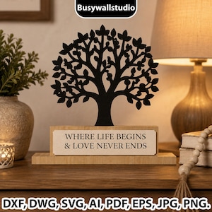 May include: A black silhouette of a tree with detailed leaves mounted on a rectangular light wood base. A white rectangular plaque is attached to the front of the base with the black text: WHERE LIFE BEGINS & LOVE NEVER ENDS.