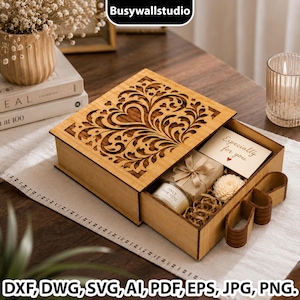 Può includere: Una scatola regalo scorrevole in legno di forma quadrata con un motivo floreale e a cuore tagliato al laser sul coperchio. Il cassetto aperto contiene un piccolo regalo con nastro, un biglietto con il testo Especially for you e un fiore.