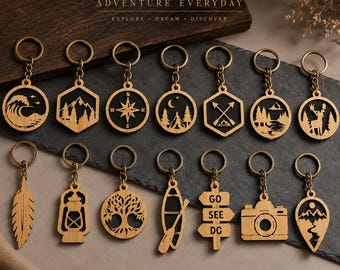 May include: A collection of fourteen wooden keychains featuring laser-cut designs including a wave, mountains, compass, tent, arrows, forest, deer, feather, lantern, tree, canoe, signpost with text GO SEE DC, camera, and a mountain peak shape.