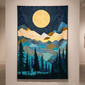 Puede incluir: Un tapiz rectangular de tela que presenta un paisaje con una gran luna amarilla sobre un cielo azul oscuro. La composición incluye cadenas montañosas superpuestas en tonos azul, turquesa y crema, con siluetas de pinos oscuros.
