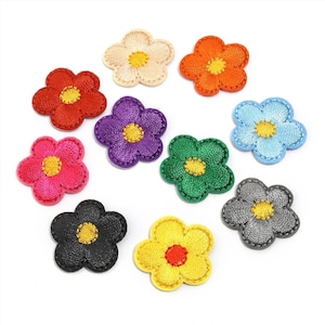 May include: A collection of ten embroidered flower patches in various colors including red, orange, yellow, green, blue, purple, pink, black, gray, and cream. Each patch features five rounded petals and a contrasting yellow or red center.