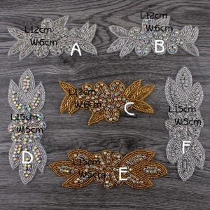 Può includere: Sei applicazioni decorative con perline etichettate dalla A alla F. Gli articoli A, B, D e F sono color argento con cristalli iridescenti, mentre C ed E sono color oro. Le dimensioni sono stampate su ciascuno: A e B misurano 12cm per 6cm, C misura 12cm per 6cm, D e F misurano 15cm per 5cm, ed E misura 15cm per 5cm.