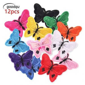 Op de afbeelding: Een set van 12 geborduurde vlinderpatches in diverse kleuren, waaronder zwart, groen, oranje, wit, roze, rood, geel, blauw en paars. Elke patch heeft een zwart geborduurd lichaam en vleugeldetails. De tekst goodqu 12pcs is zichtbaar.