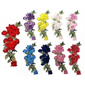Puede incluir: Una colección de nueve parches bordados de rosas en varios colores, incluyendo rojo, morado, amarillo, blanco, rosa claro, azul, azul oscuro y magenta. Cada parche presenta un grupo de tres rosas con hojas y tallos verdes.