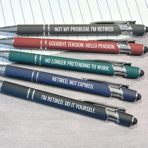 May include: A set of five retractable ballpoint pens with stylus tips, featuring silver accents and white text. The pens are colored gray, red, teal, blue, and black, each printed with retirement-themed phrases including NOT MY PROBLEM. I'M RETIRED.