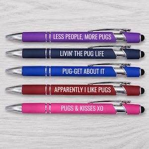 May include: Five retractable ballpoint pens with silver-toned clips and tips. The pens are purple, navy blue, blue, maroon, and pink. Each features white text: LESS PEOPLE, MORE PUGS, LIVIN' THE PUG LIFE, PUG-GET ABOUT IT, APPARENTLY I LIKE PUGS, PUGS & KISSES XO.