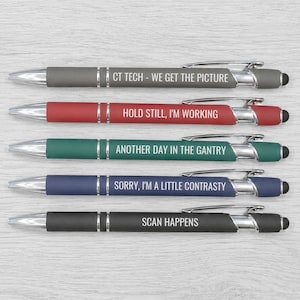 May include: Five retractable ballpoint pens with stylus tips, featuring silver accents and clips. The pens are gray, red, teal, blue, and black, each printed with white text: CT TECH - WE GET THE PICTURE, HOLD STILL, I'M WORKING, ANOTHER DAY IN THE GANTRY, SORRY, I'M A LITTLE CONTRASTY, and SCAN HAPPENS.