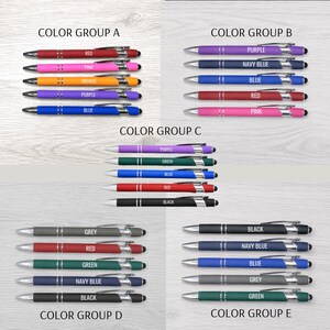 May include: A collection of ballpoint pens organized into five color groups labeled A through E. Each pen features a matte barrel, silver accents, a pocket clip, and a stylus tip. The barrels are printed with their respective color names.