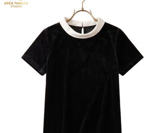 Top de terciopelo negro con cuello Peter Pan y blusa de manga corta con escote blanco en contraste.