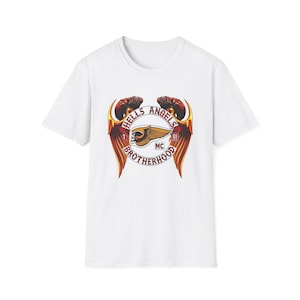 May include: A white short-sleeved t-shirt featuring a central graphic of a winged skull emblem with the text HELLS ANGELS BROTHERHOOD, the number 81, and the letters MC. The design incorporates red, orange, and yellow wings surrounding the skull.