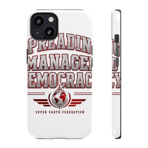 May include: A white smartphone case featuring the text SPREADING MANAGED DEMOCRACY in a metallic silver and red font. Below the text is a graphic of a globe surrounded by red wings and the text SUPER EARTH FEDERATION in a dark red font.