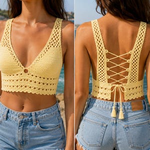 May include: A pale yellow crochet crop top featuring a deep V-neckline with a central ring detail, wide shoulder straps, and a scalloped hem. The back displays an open design with crisscross lace-up ties that end in two small tassels.