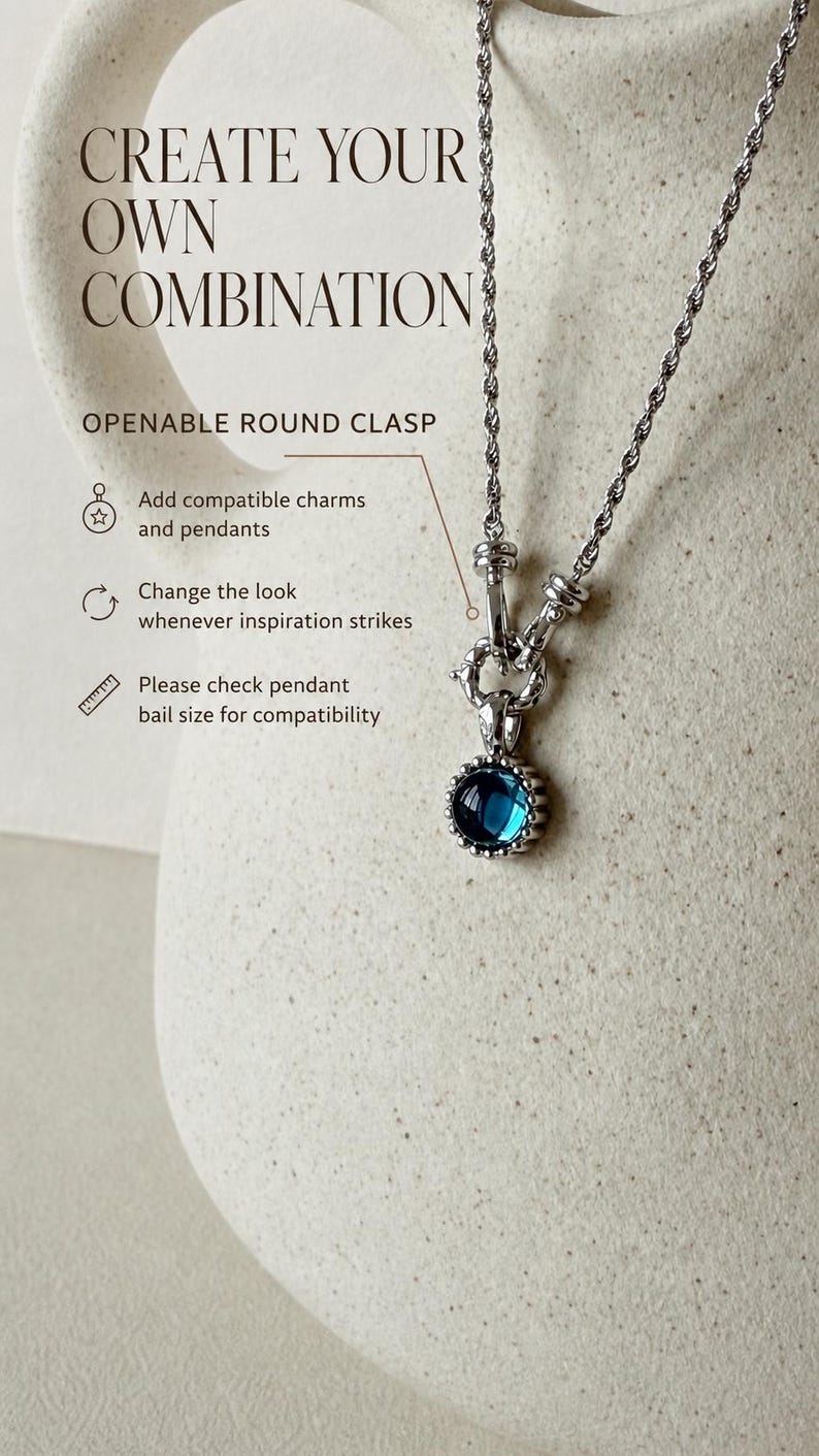 Pode incluir: Um colar de corrente de corda prateada com um fecho redondo que pode ser aberto e um pingente circular com uma pedra azul profunda. O texto diz: CREATE YOUR OWN COMBINATION, OPENABLE ROUND CLASP, Add compatible charms and pendants, Change the look whenever inspiration strikes, Please check pendant bail size for compatibility.