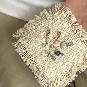 Pode incluir: Uma cole&ccedil;&atilde;o de seis pequenos pingentes de metal, incluindo dois pingentes em forma de cruz com pedras transparentes, um pingente de estrela, um pingente de cora&ccedil;&atilde;o, um pingente circular com centro azul e uma cruz com pedras violeta claro.