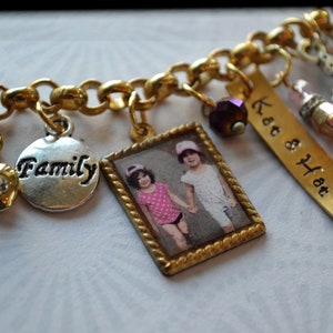 May include: Gold charm bracelet with various charms, including a silver charm with the word "Family", a photo charm of two girls, and a gold charm with the text "Kat & Hat".
