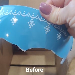 Puede incluir: Un tazón de cerámica azul con un diseño de copo de nieve blanco y un borde festoneado. El tazón está astillado y roto. La palabra "Antes" está escrita debajo del tazón.