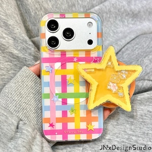May include: A clear phone case featuring a colorful plaid pattern of pink, orange, yellow, green, and blue stripes with small star icons. A yellow star-shaped phone grip with internal glitter accents is attached to the back. The text Starry Sky is printed on the case.