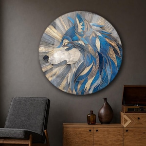 May include: A circular wall art piece featuring a stylised wolf head in profile. The artwork uses a layered, textured design with deep blue, metallic gold, and silver tones, creating a radiating sunburst effect behind the wolf's head.