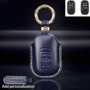 May include: A dark blue leather car key fob cover with white stitching, featuring a gold-toned circular metal ring with an H-shaped connector. The cover has molded button icons and includes a separate rectangular tag with the number 13888888888.