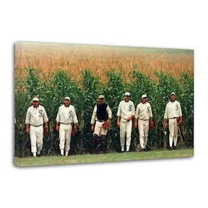 May include: A rectangular canvas print featuring six baseball players in vintage white uniforms with the letter S on the chest, standing in a line in front of a tall green cornfield. The players wear matching caps and pants, with some holding gloves.