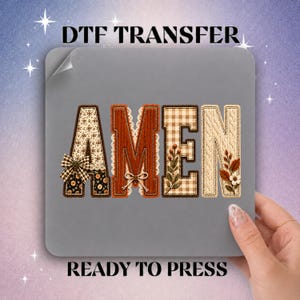 May include: A DTF transfer sheet featuring the word AMEN in large block letters. The letters have varied textures including floral patterns, corduroy, gingham, and cable knit, accented with small bows and botanical illustrations in autumn colors.
