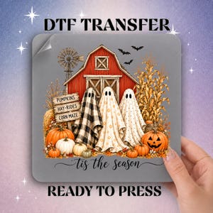 May include: A square DTF transfer sheet featuring a red barn, a windmill, and three ghosts draped in patterned sheets. A wooden sign reads PUMPKINS, HAY-RIDES, CORN MAZE. Below, orange pumpkins and the text tis the season are printed on a gray background.