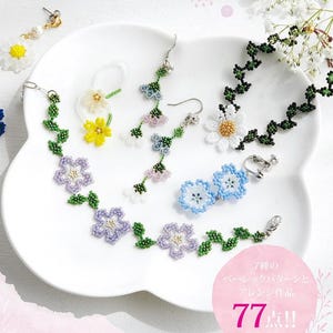 May include: A collection of beaded jewelry including a purple flower bracelet, a white daisy necklace, blue flower clip-on earrings, and dangling earrings with green stems and small flowers. A pink circular graphic includes the text 7種のベーシックパターンとアレンジ作品 77点!!