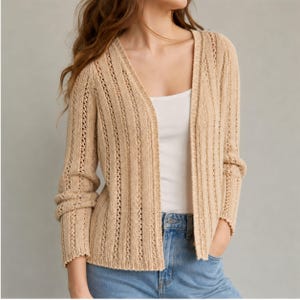 Könnte beinhalten: Eine beige, vorne offene Strickjacke mit vertikalem Rippenstrickmuster und zarten Lochmusterdetails. Das langärmelige Kleidungsstück wird über einem schlichten weißen Tanktop und einer hellblauen Jeans getragen und zeigt eine strukturierte Strickoptik.