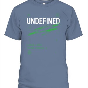 May include: A slate blue short-sleeve t-shirt featuring the white text UNDEFINED centered on the chest. Below the text is a green brushstroke graphic and additional small green text that reads [ ERROR : 404 ] and [ TYPE_NAME : UNDEFINED ].