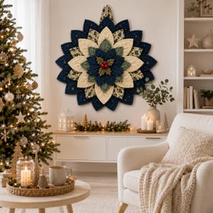 May include: A circular fabric wall hanging shaped like a poinsettia flower, featuring layered petals in navy blue, cream, and green floral patterns. The center is accented with three small red berries and green leaves, all with quilted textures.