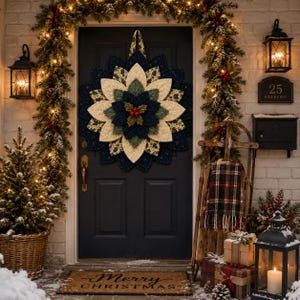 May include: A fabric star-shaped wall hanging featuring layered petals in cream, dark green, and navy blue with a central cluster of red berries and green leaves, displayed on a dark door with a Merry Christmas doormat and holiday decor.