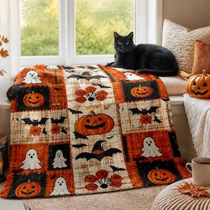 May include: A rectangular throw blanket featuring a patchwork pattern of Halloween motifs including orange jack-o'-lanterns, white ghosts, black bats, and witch hats on a background of orange and cream plaid and solid black squares.